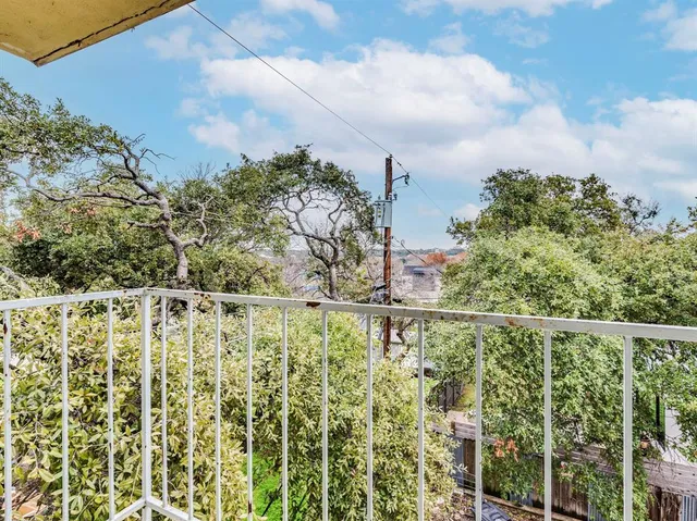a view of a yard with plants and wooden fence
