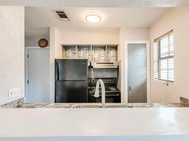 a kitchen with a refrigerator and a sink
