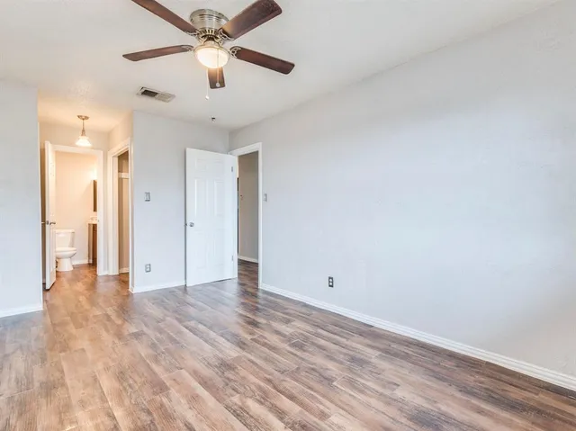 a view of an empty room and window a ceiling fan