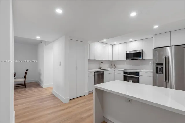 a kitchen with a refrigerator stove and wooden floor