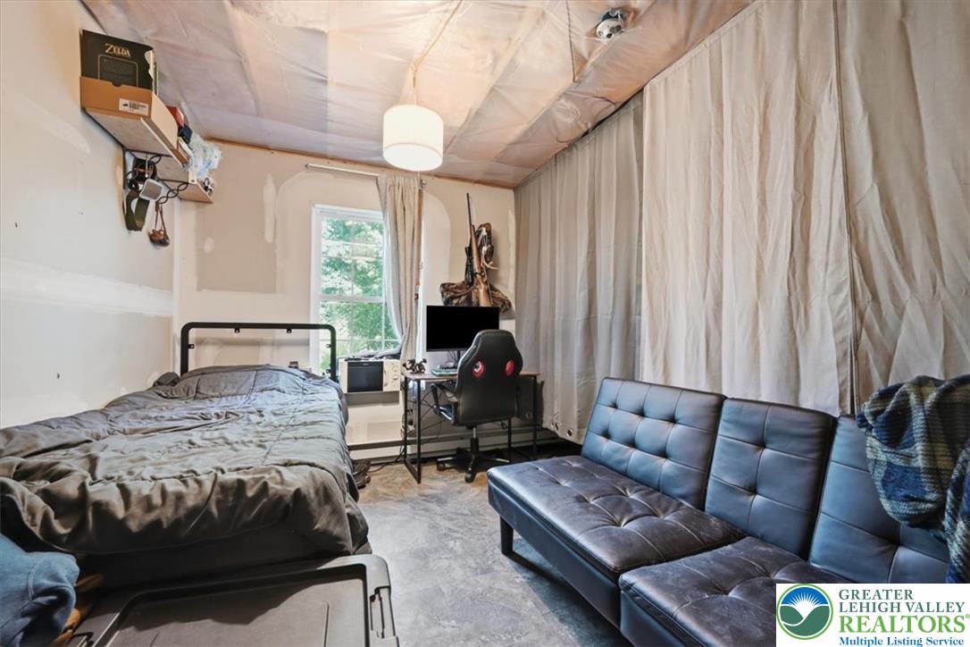 128 Chestnut Street Dingmans Ferry, PA 18328 - Photo 26 of 43 An adaptable living space features a large window with leafy views and resilient concrete flooring.