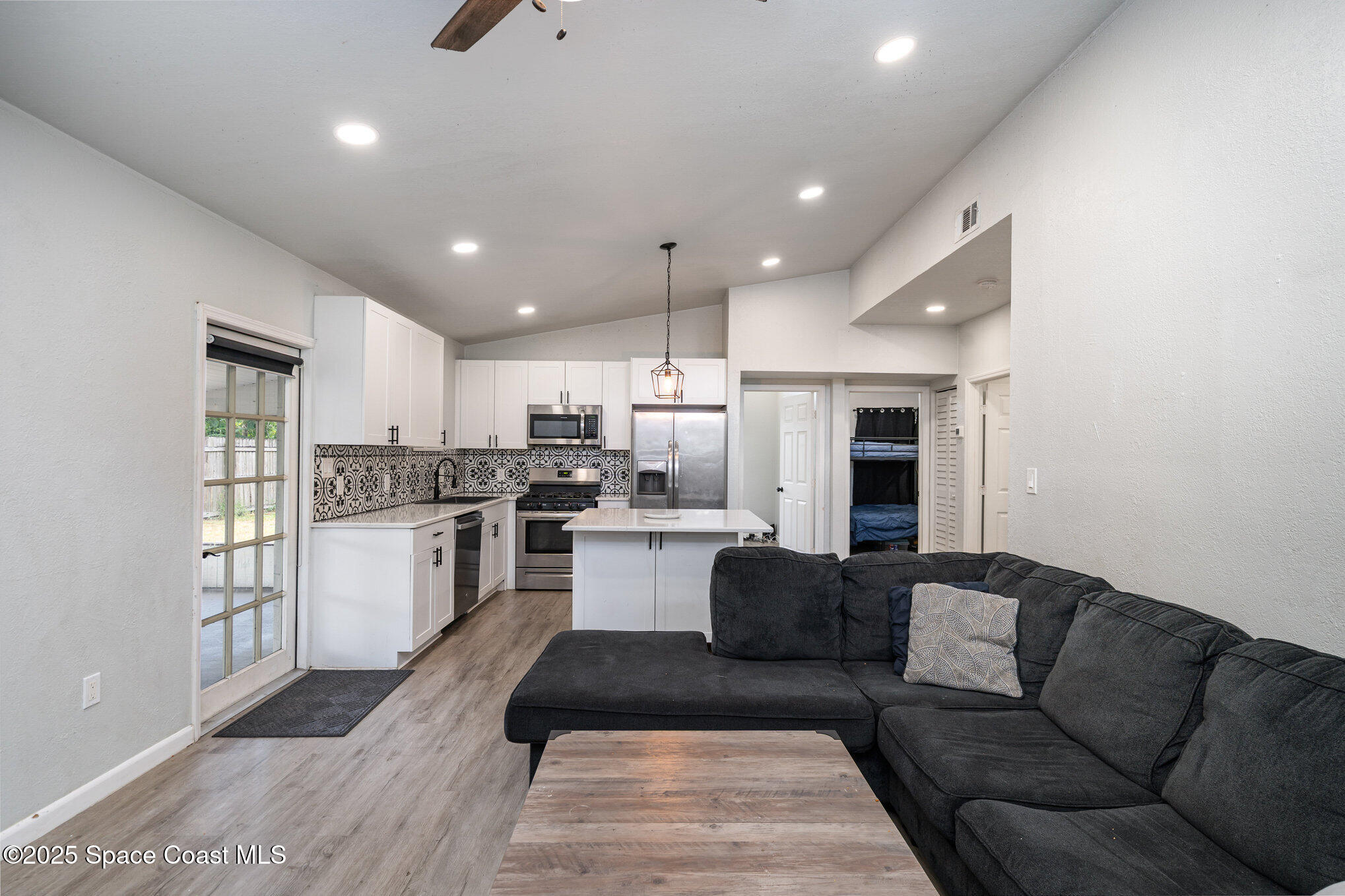 2158 Laden Road Melbourne, FL 32935 - Photo 6 of 19 a kitchen with a refrigerator and white cabinets