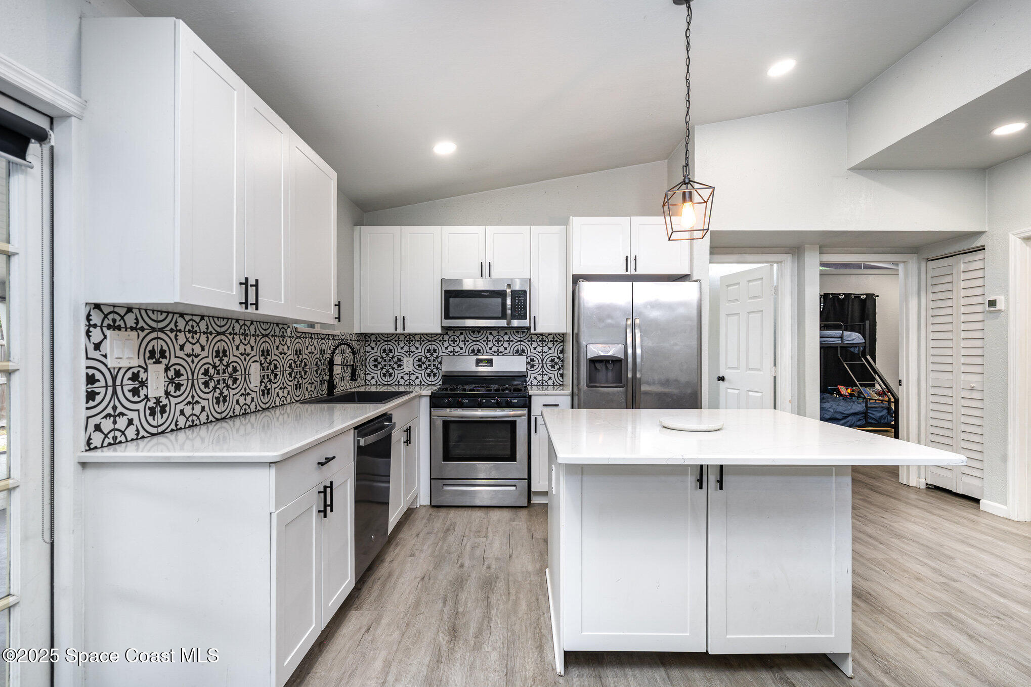 2158 Laden Road Melbourne, FL 32935 - Photo 7 of 19 a kitchen with kitchen island stainless steel appliances a sink and refrigerator