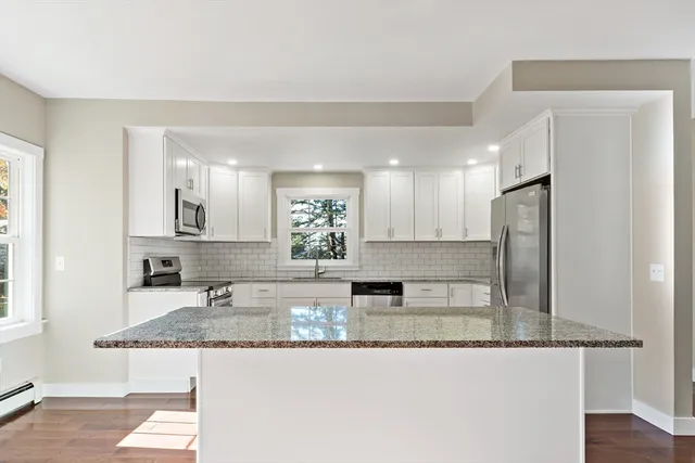 a kitchen with stainless steel appliances granite countertop a sink refrigerator and microwave