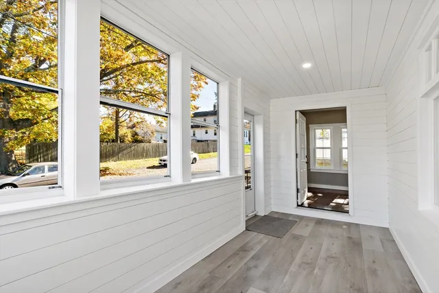 a view of an empty room with a window and a bathroom