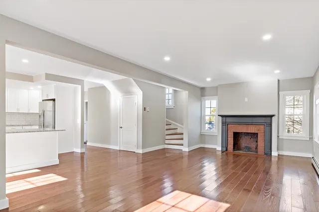 an empty room with wooden floor and fireplace