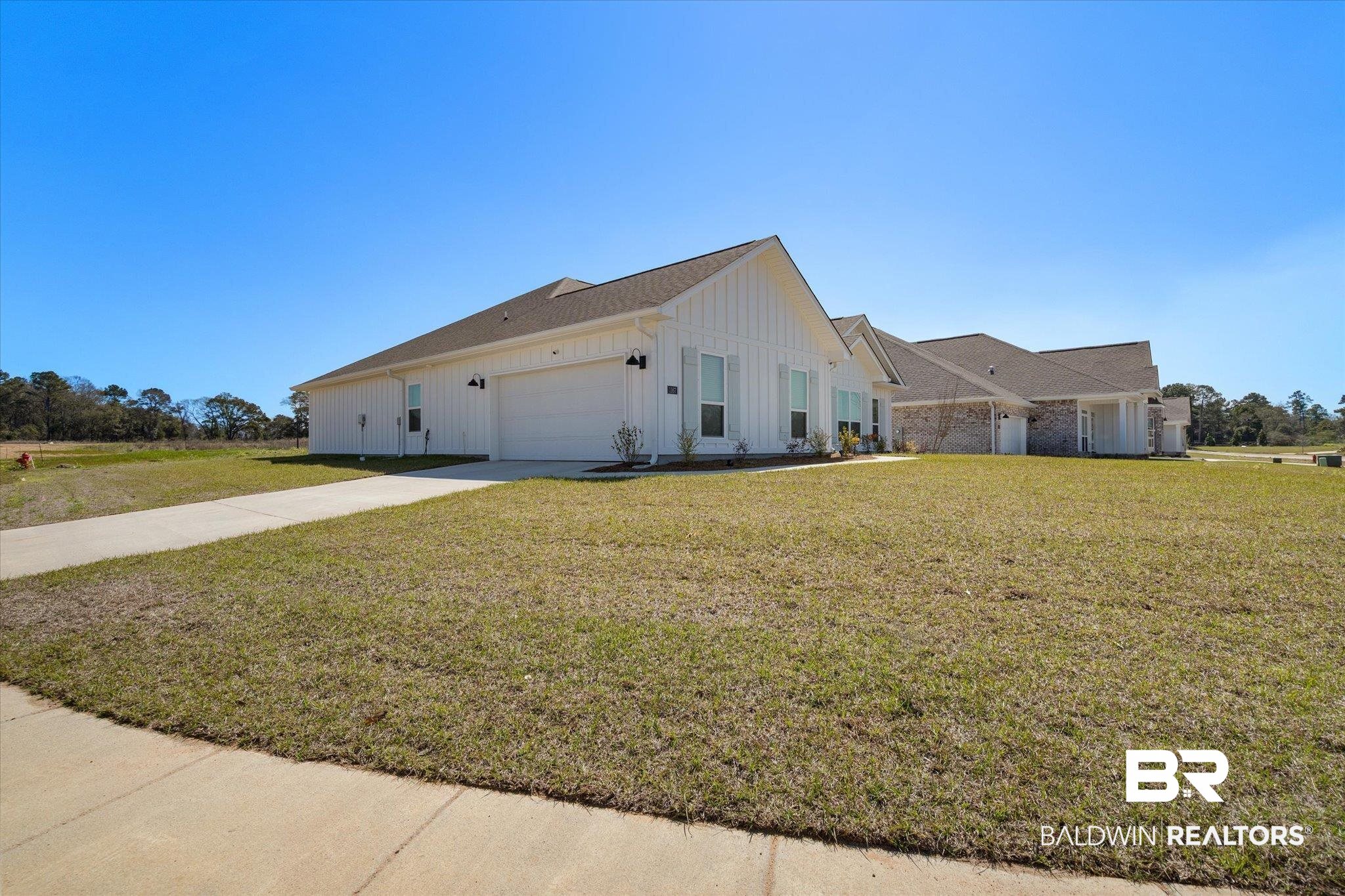 1167 Provision Road Mobile, AL 36608 - Photo 19 of 20 View of home's exterior with a garage, a lawn, board and batten siding, and concrete driveway