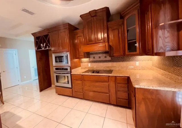a kitchen with stainless steel appliances granite countertop a stove and a refrigerator