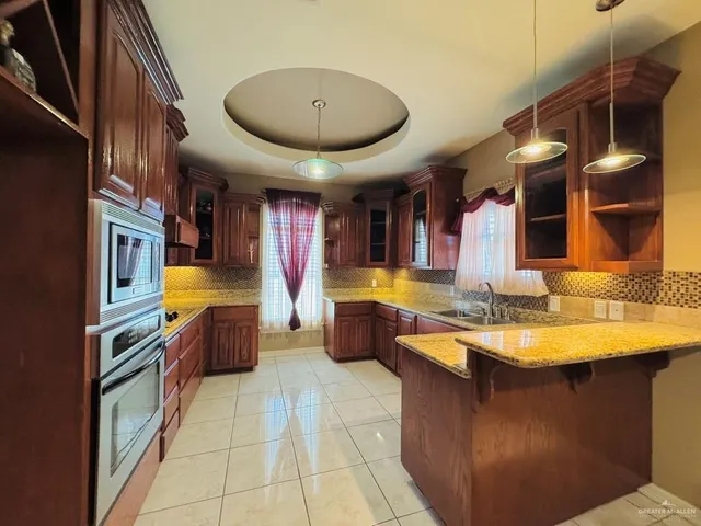 a kitchen with stainless steel appliances granite countertop a sink and a refrigerator