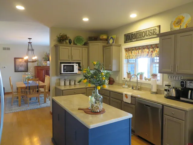 a bedroom with a bed a lamp on dresser and a chandelier