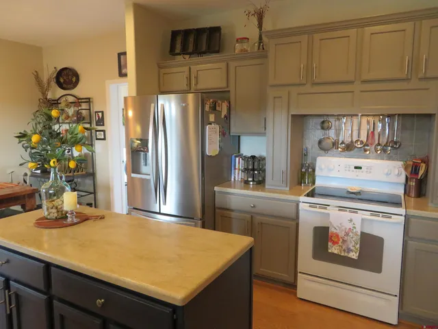 a kitchen with stainless steel appliances granite countertop a refrigerator a stove and a sink