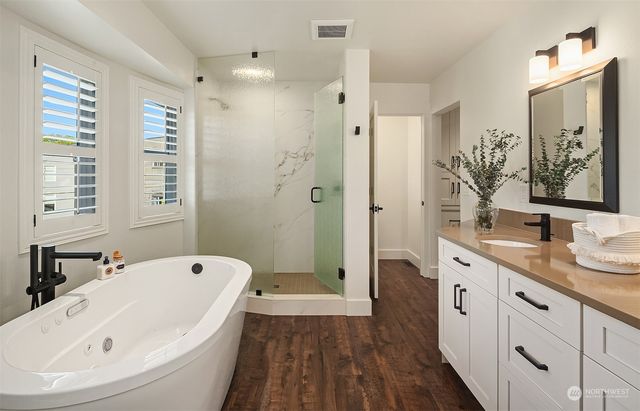 a bathroom with a tub sink and mirror