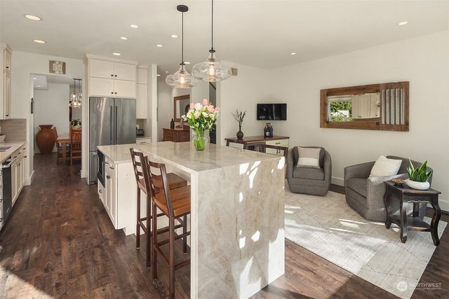 a view of a dining room and livingroom with furniture wooden floor a chandelier