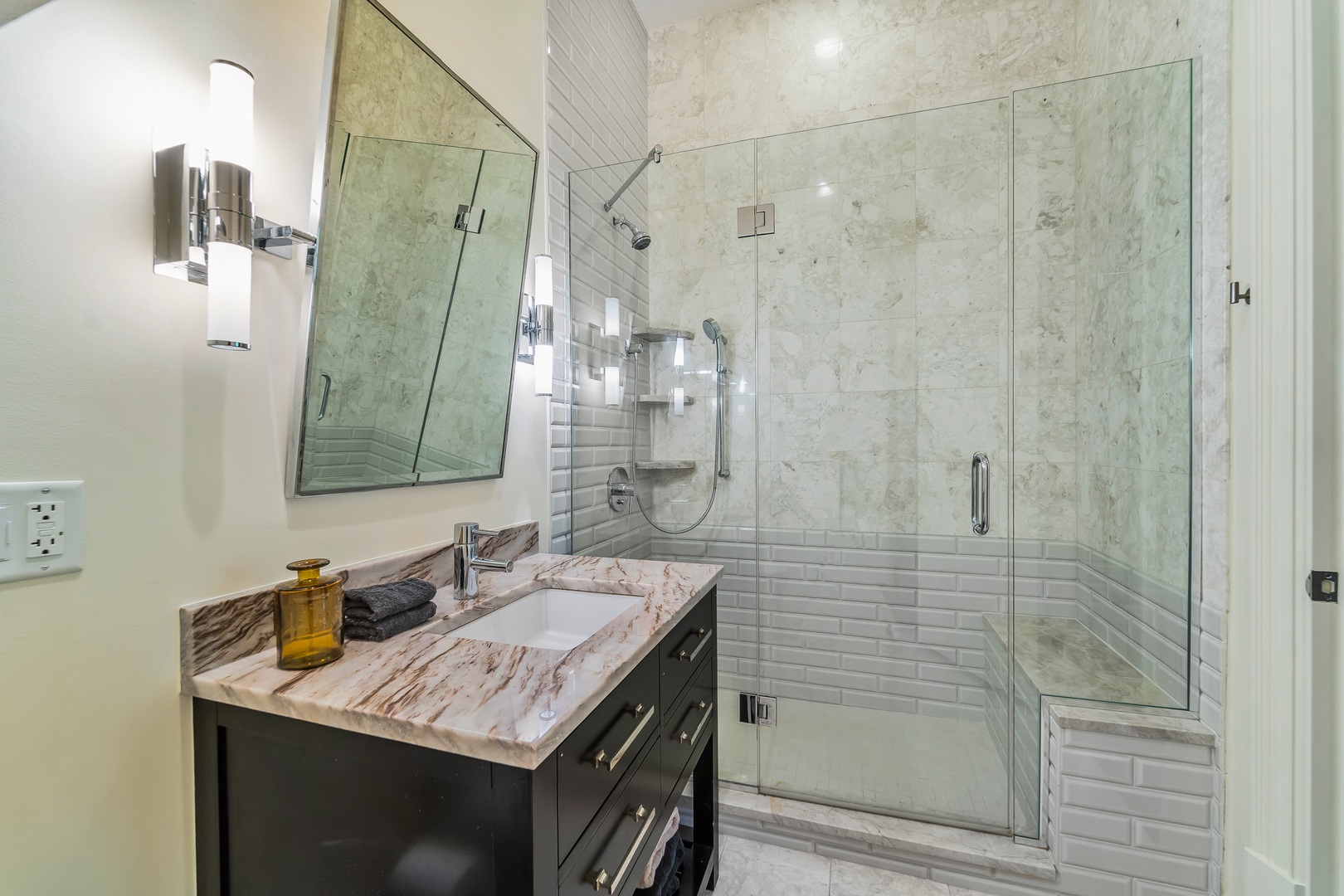 53 East Division Street Chicago, IL 60611 - Photo 36 of 78 a bathroom with a granite countertop sink a mirror and shower