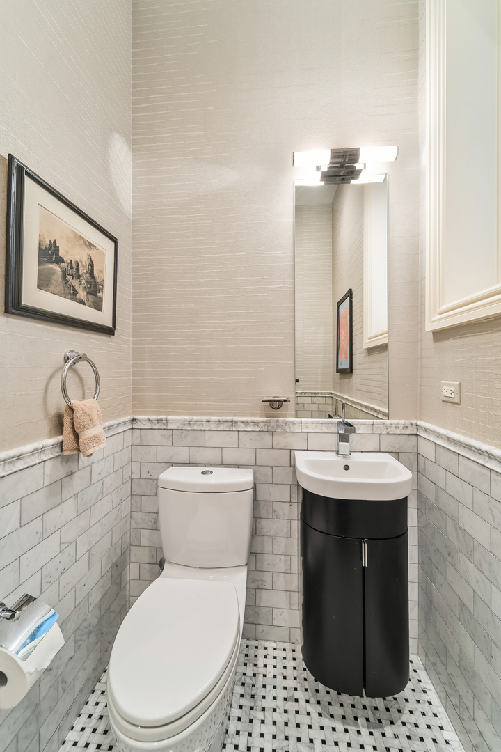 53 East Division Street Chicago, IL 60611 - Photo 42 of 78 a bathroom with a toilet a sink and mirror