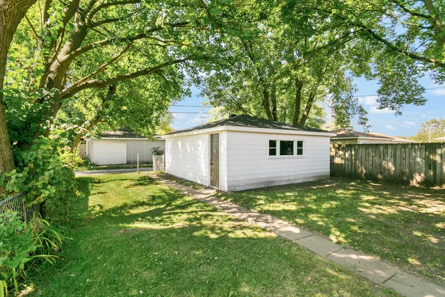 a view of a yard in front of a house with large tree