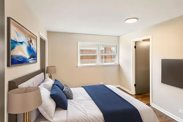 a bedroom with a bed and a painting on the wall