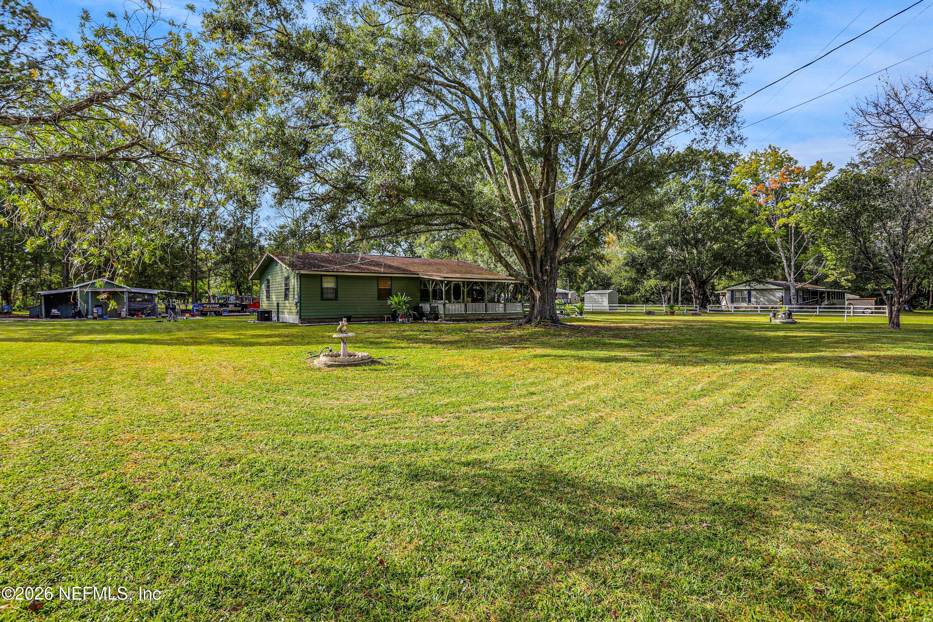 1702 Balboa Lane Middleburg, FL 32068 - Photo 21 of 31 a view of a swimming pool with lawn chairs and large trees