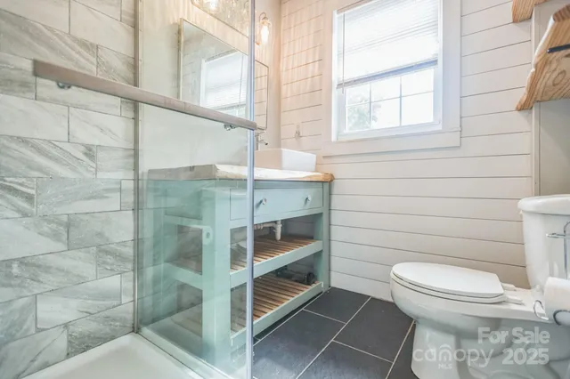 a bathroom with a toilet and a shower