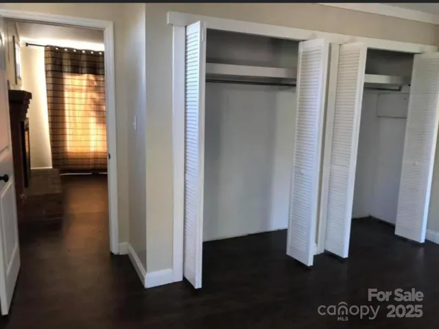 a view of a hallway with wooden floor and closet
