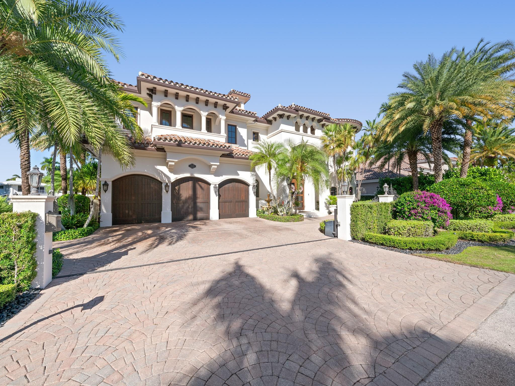 2319 Northeast 28th Street Lighthouse Point, FL 33064 - Photo 3 of 59 a front view of a house with a yard and garage
