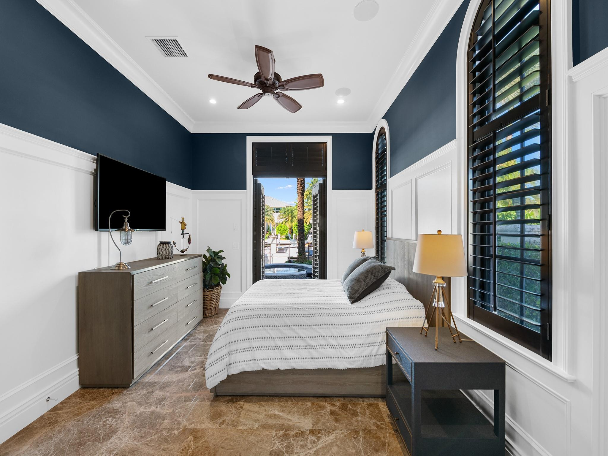 2319 Northeast 28th Street Lighthouse Point, FL 33064 - Photo 35 of 59 a bedroom with a bed a flat screen tv and a large window