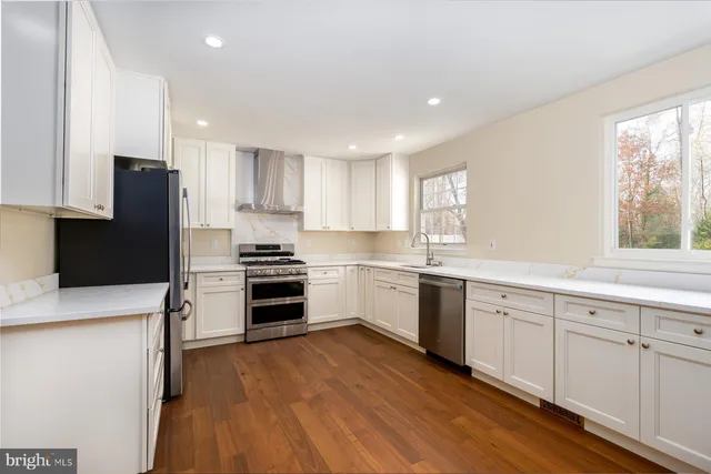 a kitchen with granite countertop white cabinets and stainless steel appliances
