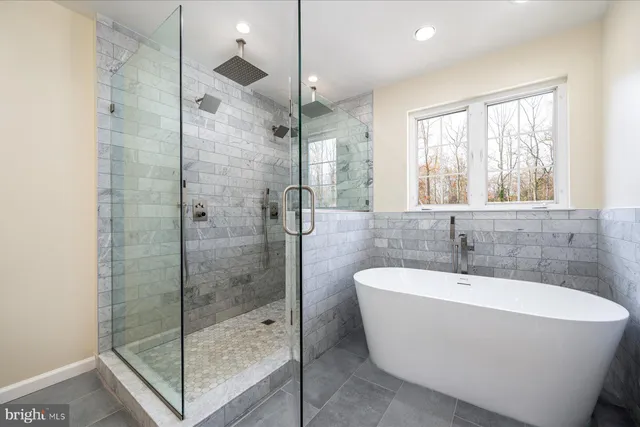 a bathroom with a white bath tub sitting next to a window
