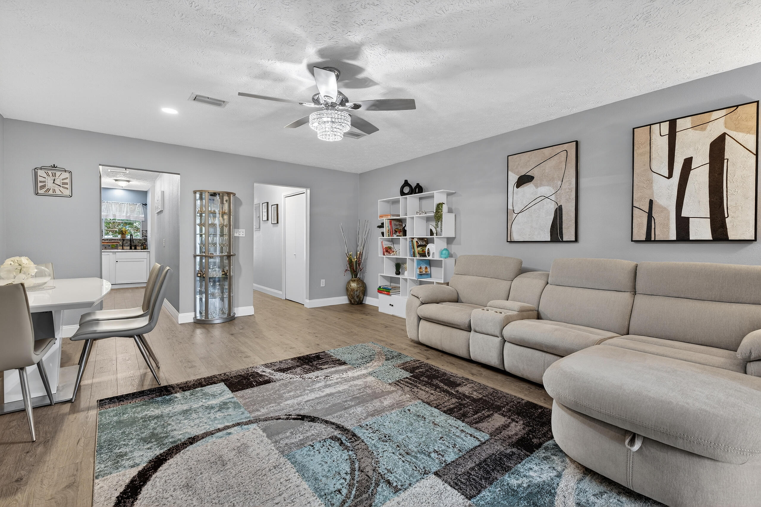 a living room with furniture and a view of kitchen