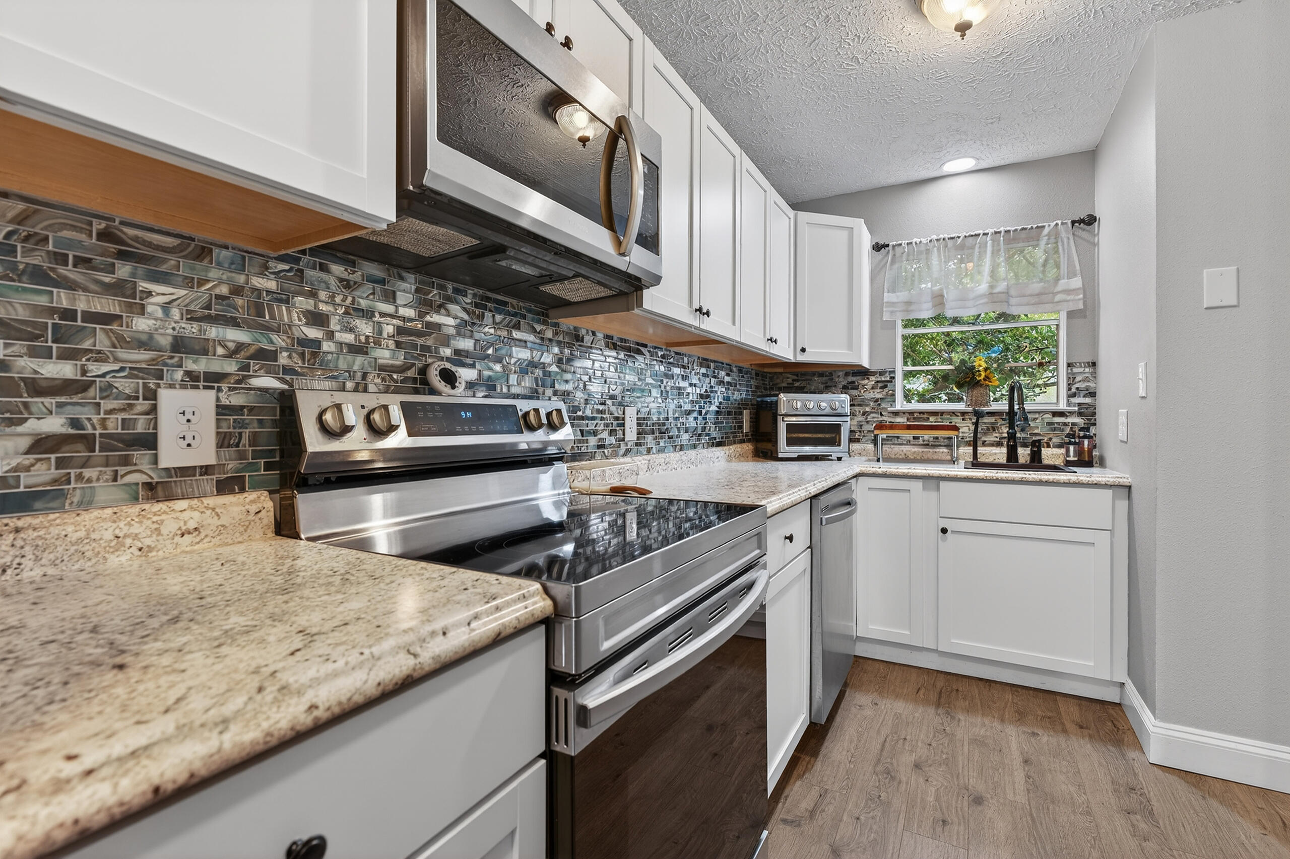 35 10th Street, Unit D Shalimar, FL 32579 - Photo 11 of 33 a kitchen with stainless steel appliances granite countertop a stove a sink and a microwave