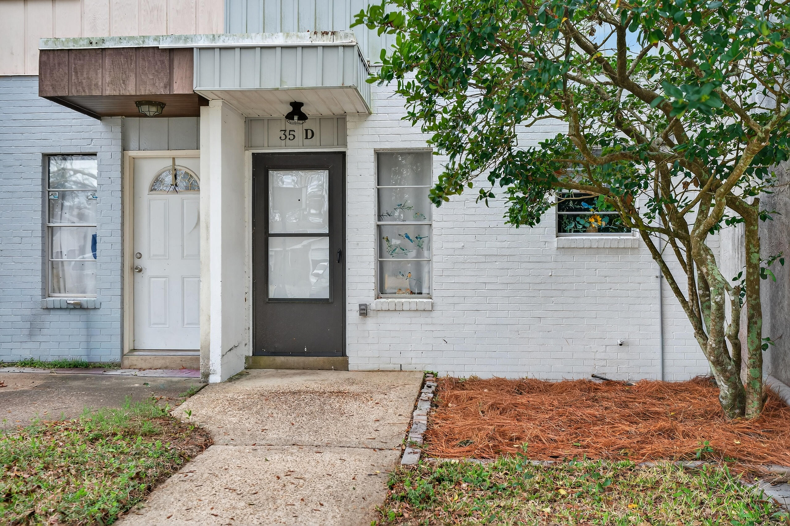 35 10th Street, Unit D Shalimar, FL 32579 - Photo 4 of 33 a front view of a house with glass windows and brick walls