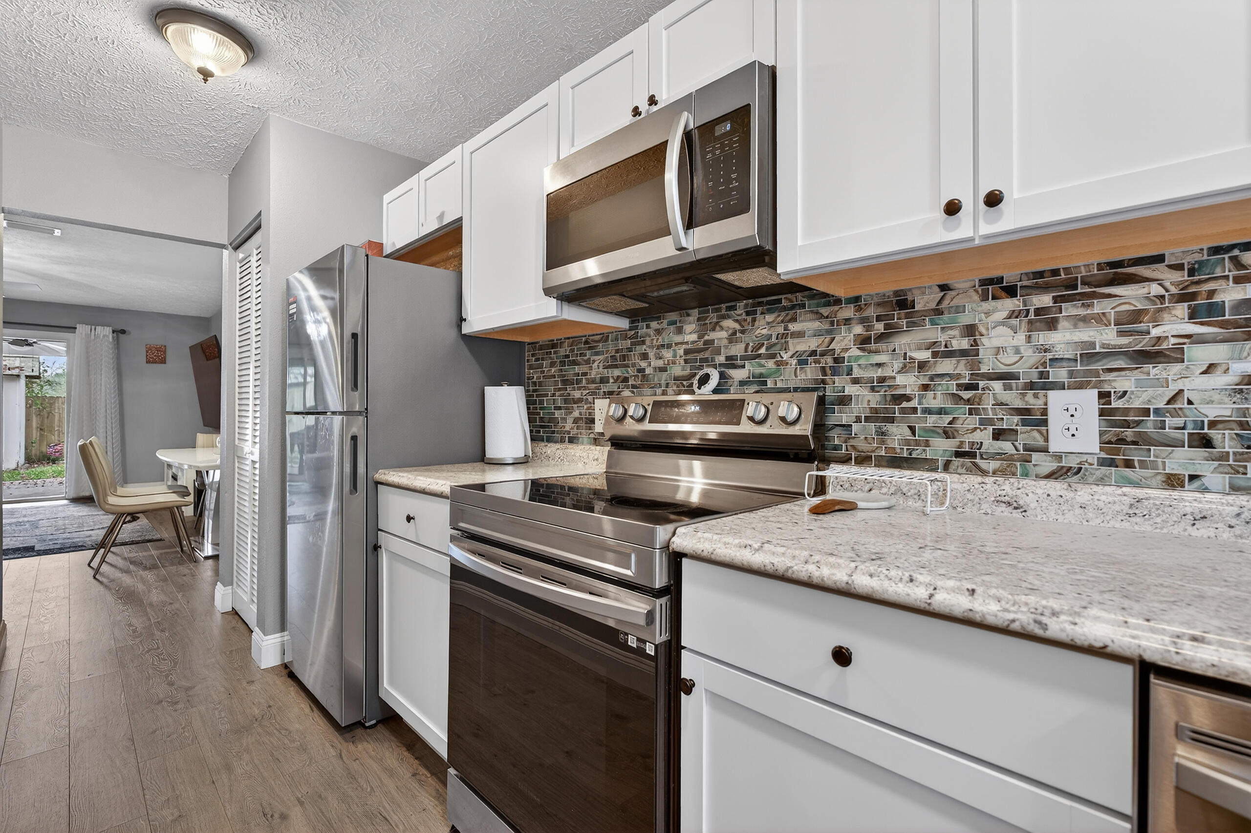 35 10th Street, Unit D Shalimar, FL 32579 - Photo 9 of 33 a kitchen with stainless steel appliances granite countertop a refrigerator stove and white cabinets