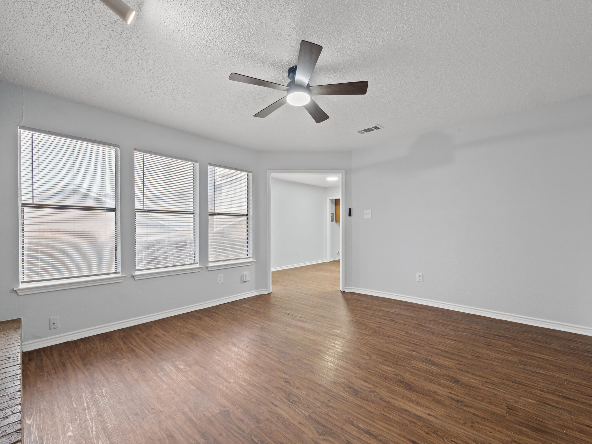 1816 Rawhide Loop, Unit 1822 Round Rock, TX 78681 - Photo 2 of 17 Spare room featuring ceiling fan, dark wood-style flooring, and a textured ceiling