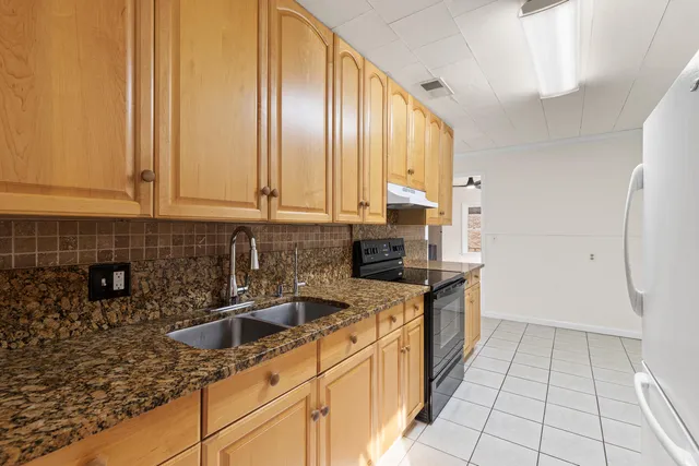 a kitchen with stainless steel appliances granite countertop a sink stove and cabinets