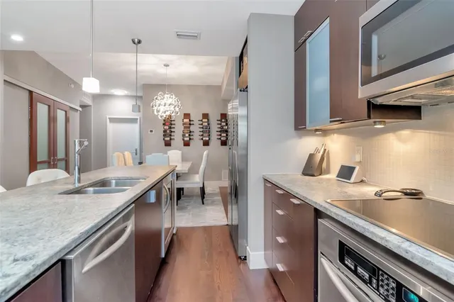 a kitchen with kitchen island granite countertop a sink a counter space appliances and cabinets