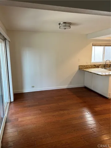 a view of a kitchen with wooden floor and a sink
