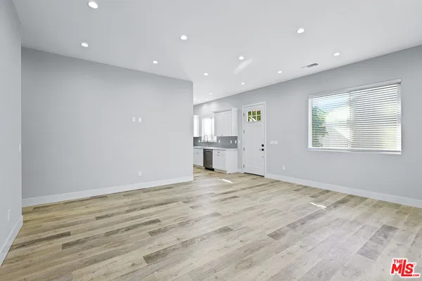 a view of empty room with wooden floor