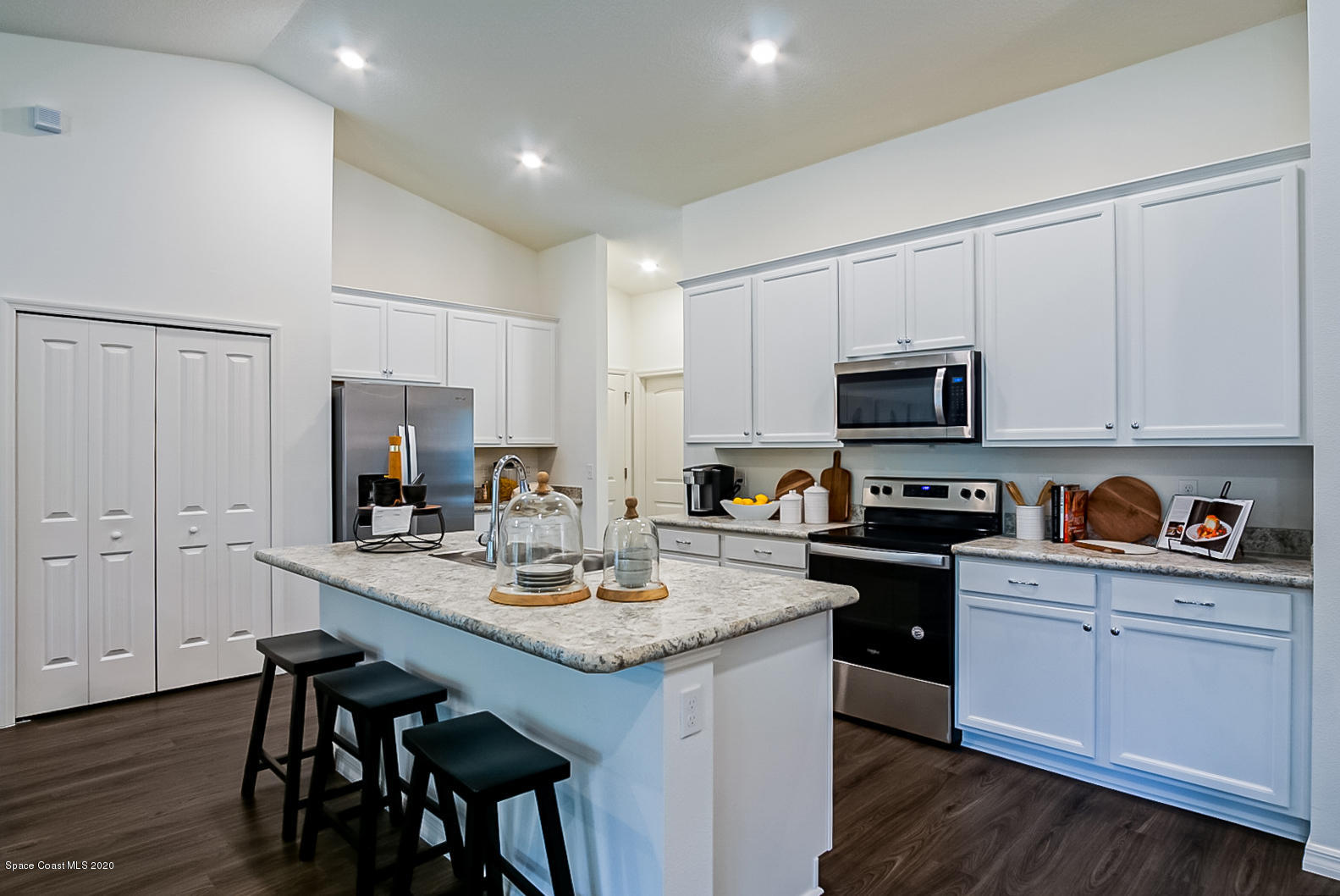 261 Abalone Road Northwest Palm Bay, FL 32907 - Photo 2 of 18 a kitchen with kitchen island granite countertop a sink cabinets and wooden floor
