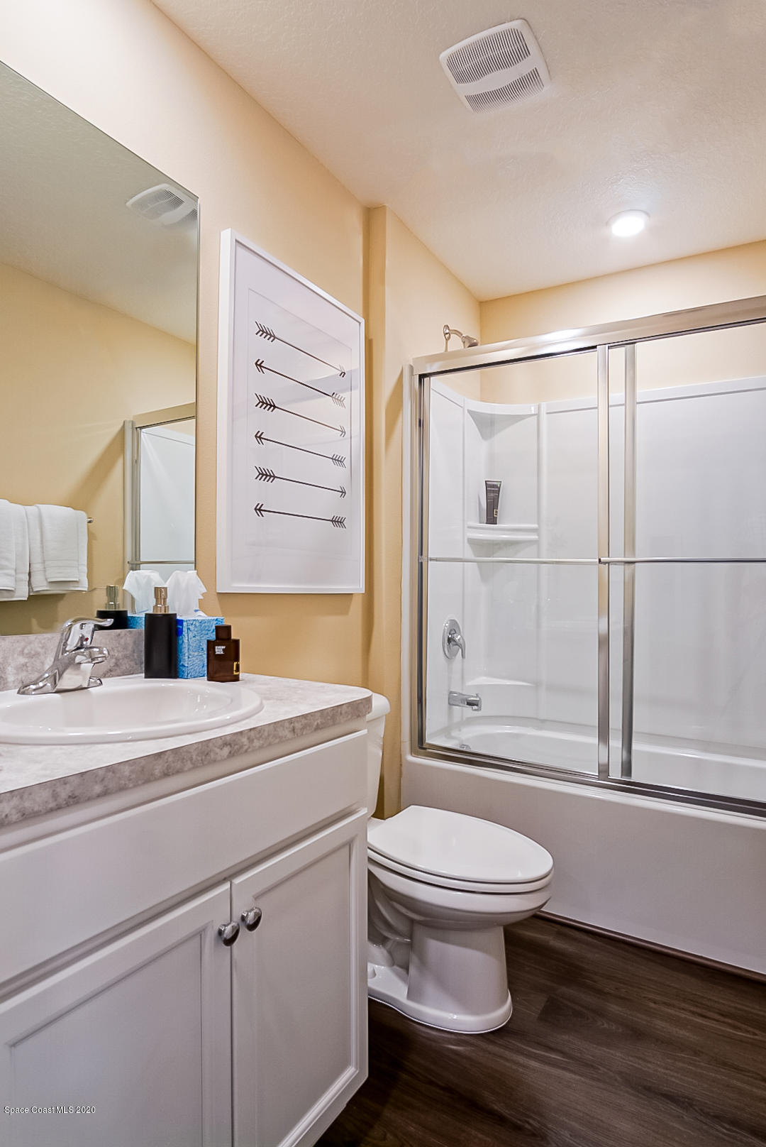 261 Abalone Road Northwest Palm Bay, FL 32907 - Photo 14 of 18 a bathroom with a sink a toilet and a large mirror