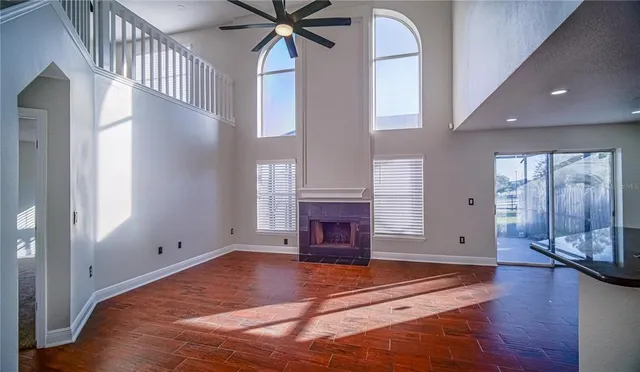 a view of an entryway with a fireplace wooden floor and windows