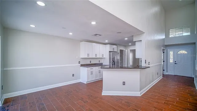 a large kitchen with stainless steel appliances kitchen island a large counter top and a wooden floors