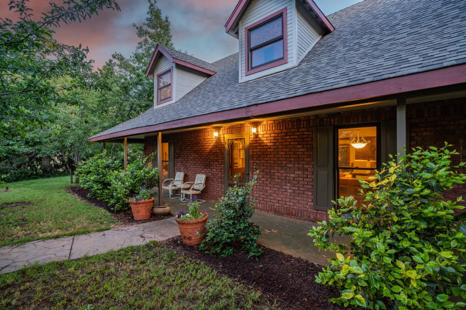 a backyard of a house with plants and outdoor seating