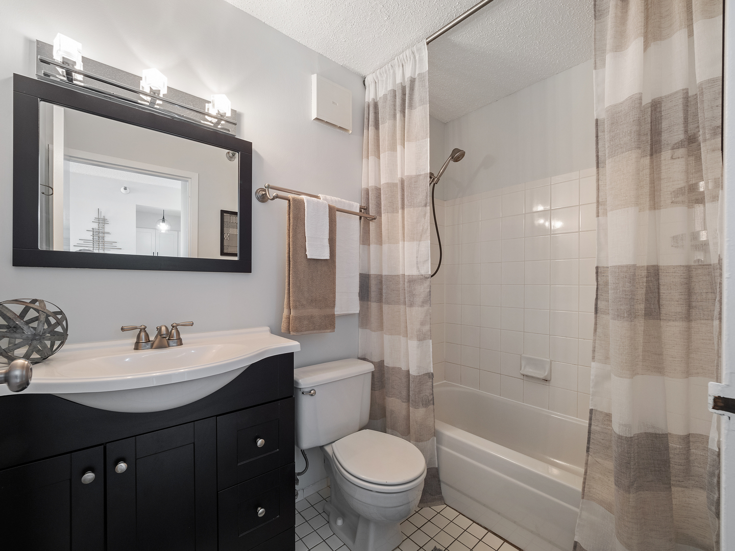 111 West Maple Street, Unit 2010 Chicago, IL 60610 - Photo 16 of 20 a bathroom with a bathtub shower sink mirror and toilet