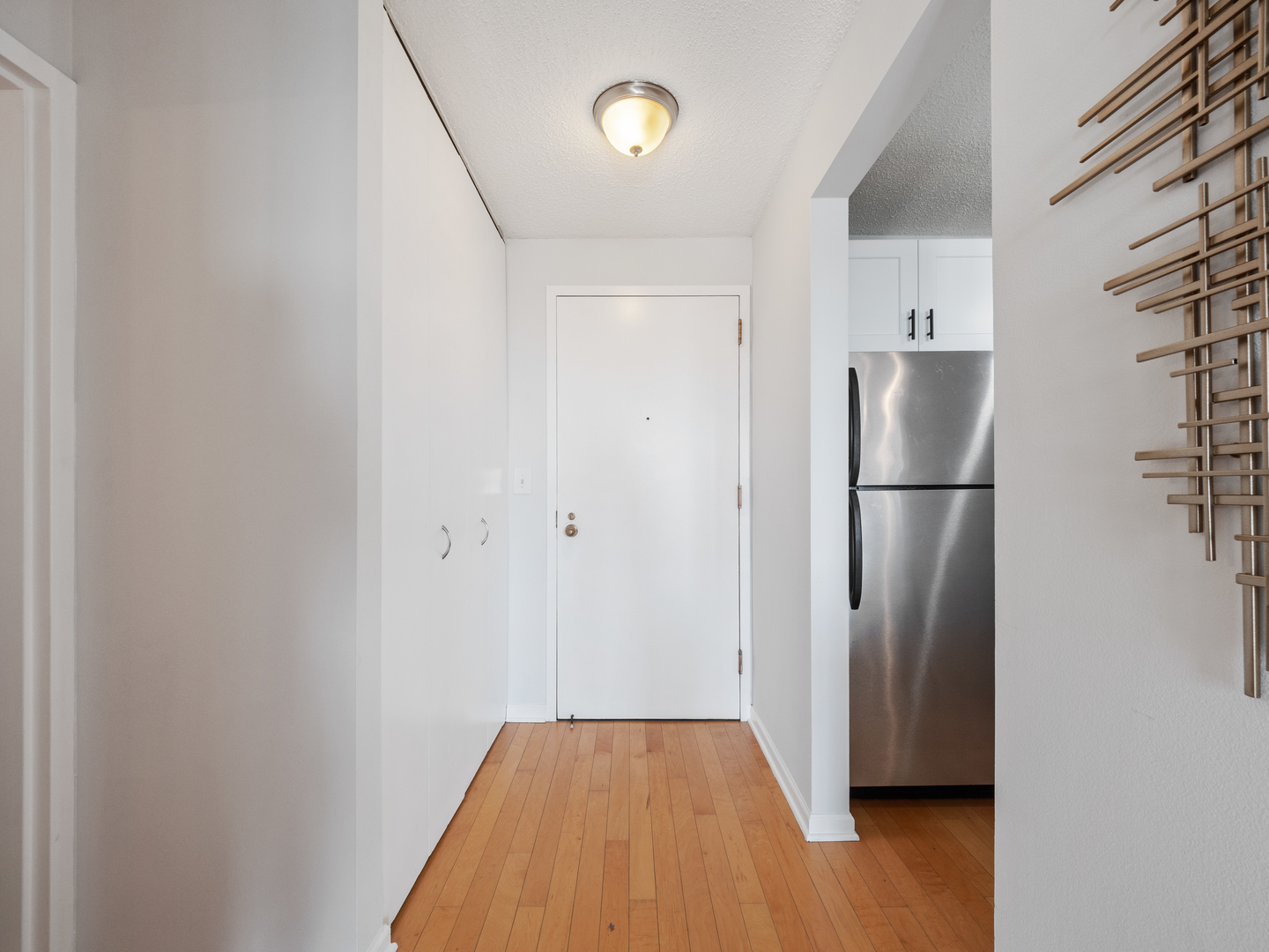 111 West Maple Street, Unit 2010 Chicago, IL 60610 - Photo 4 of 20 a view of a room with wooden floor and a refrigerator