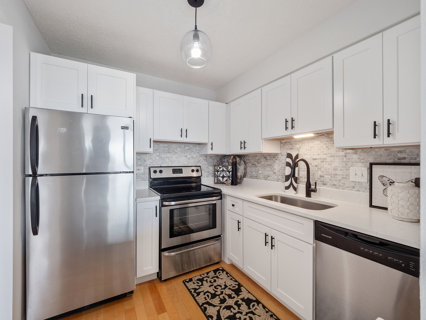 111 West Maple Street, Unit 2010 Chicago, IL 60610 - Photo 10 of 20 a kitchen with stainless steel appliances granite countertop a refrigerator sink and white cabinets