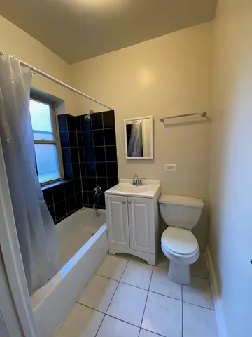 a bathroom with a toilet a sink a mirror a bathtub and shower