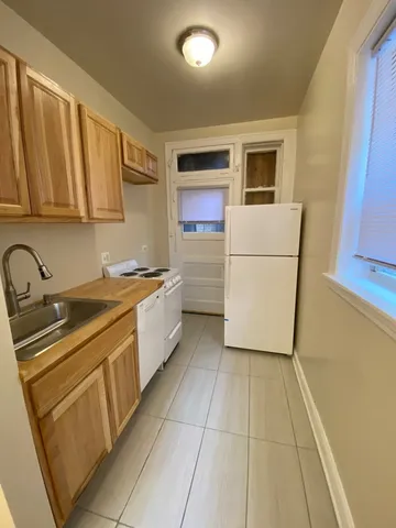 a kitchen with a refrigerator sink and cabinets