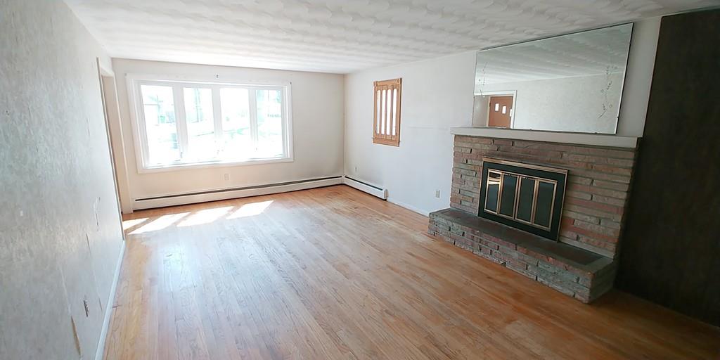 28 Intervale Road Springfield, MA 01118 - Photo 8 of 12 an empty room with wooden floor fireplace and windows