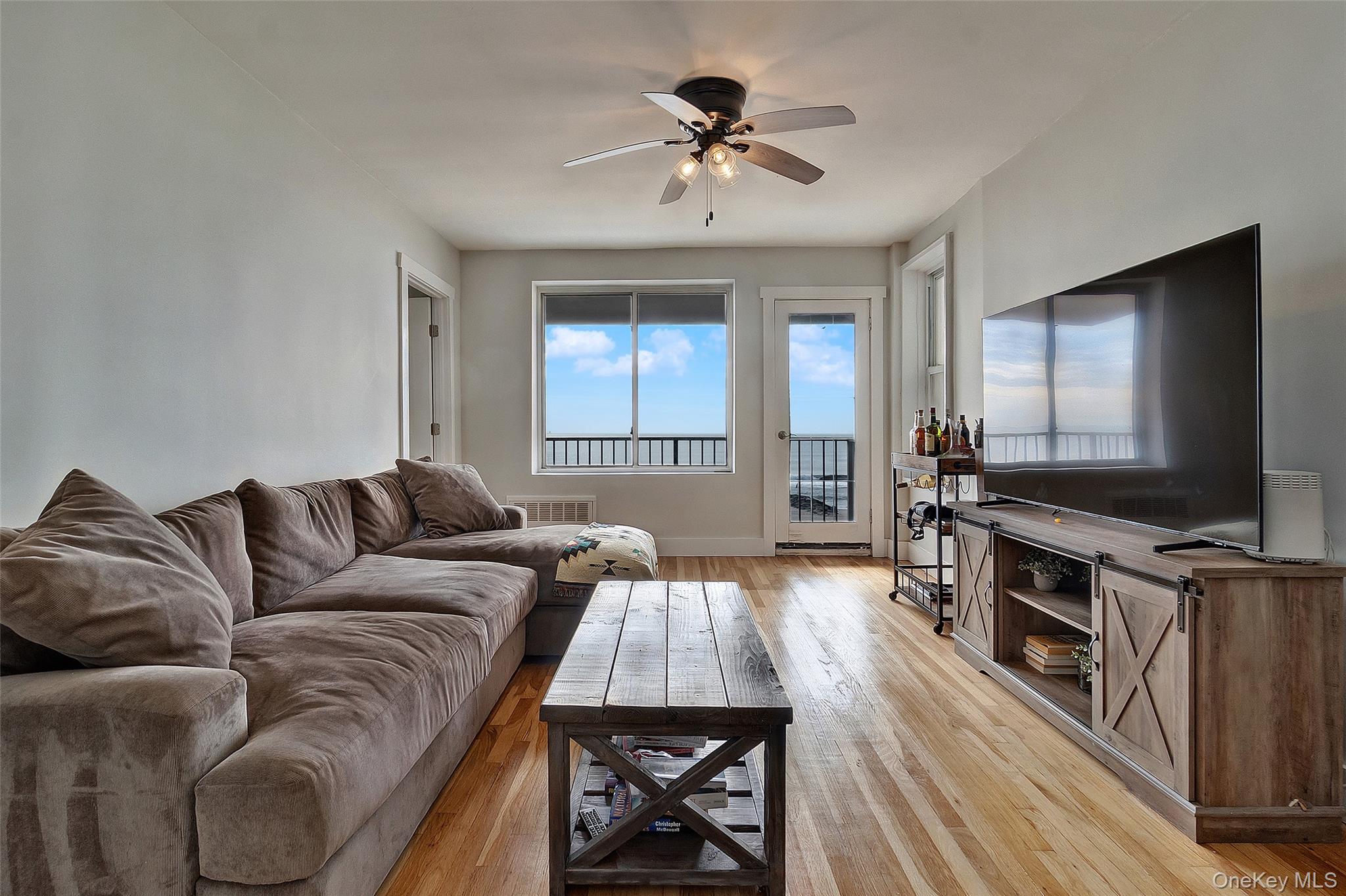 Living area with light wood-type flooring and a ceiling fan