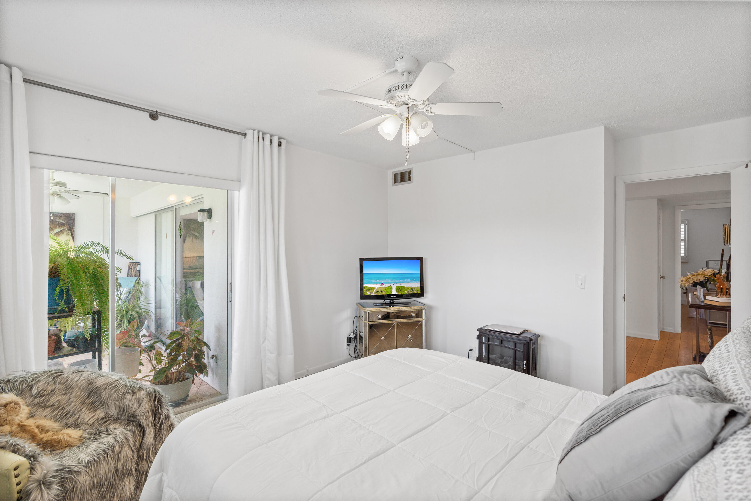 25 Southeast 13th Street, Unit B3 Boca Raton, FL 33432 - Photo 16 of 26 a bedroom with a large bed and a chandelier